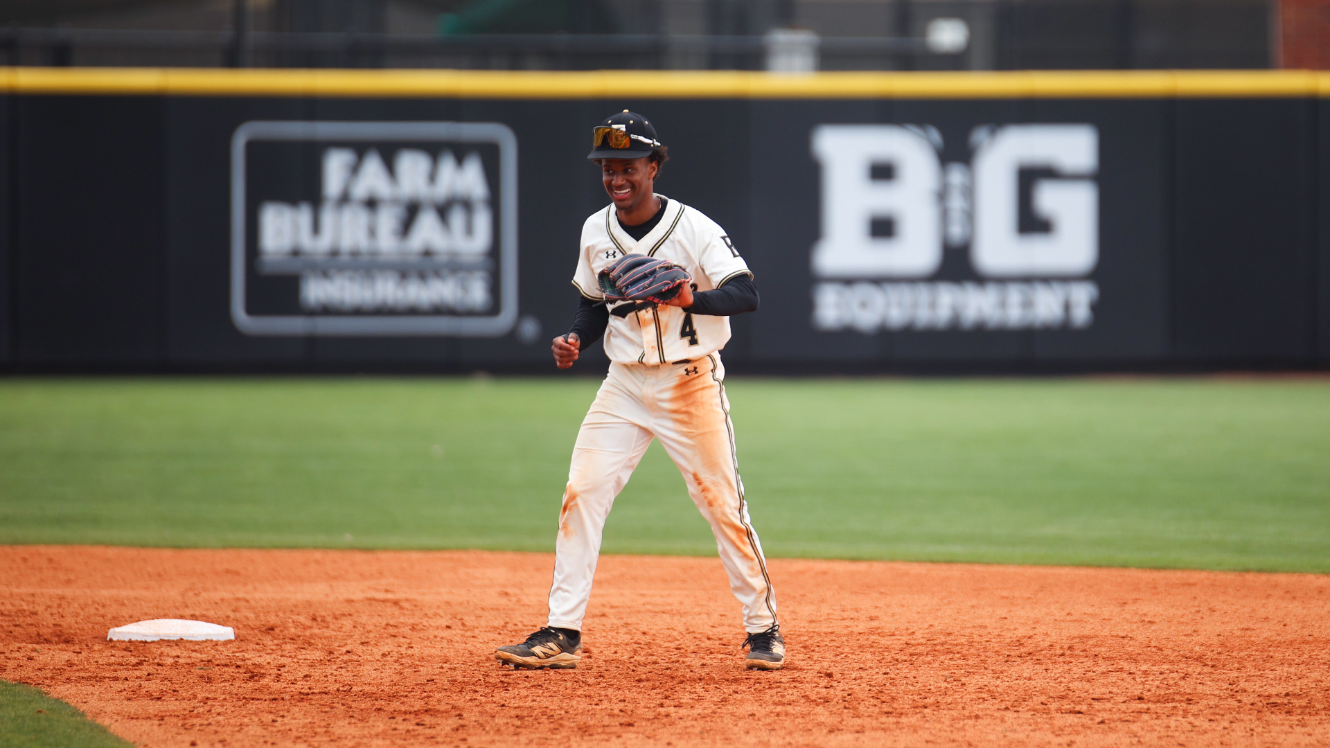 ECCC Baseball Player, Jacob Wooten. Jacob is holding up his glove and smiling. 